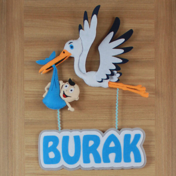 Yakın çekim: Leylek figürü ve mavi kundak içindeki bebek detayı
