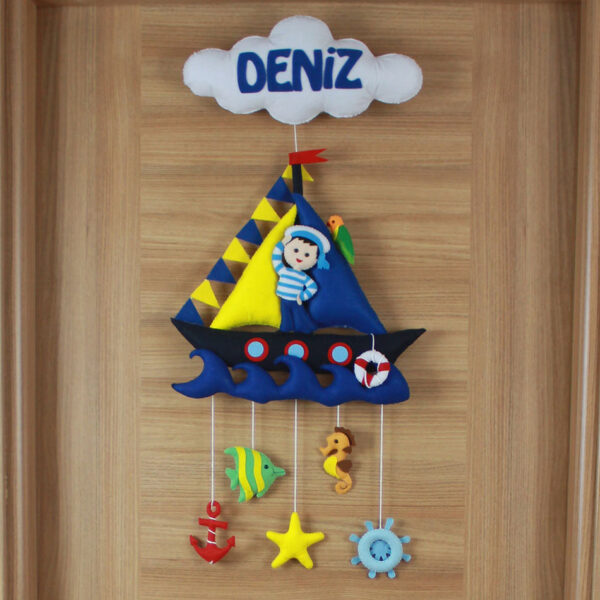 Yakın çekim: Keçe yelkenli tekne, denizci figürü ve bulut detayı