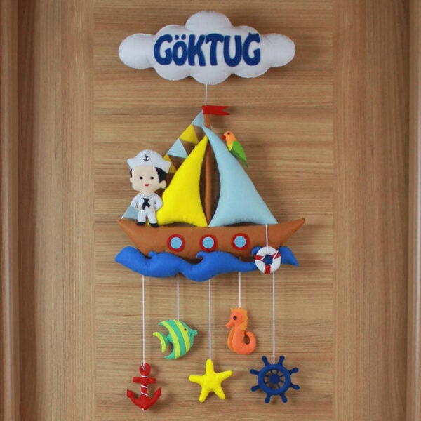Yakın çekim: Yelkenli tekne, denizci bebek ve papağan figürleri