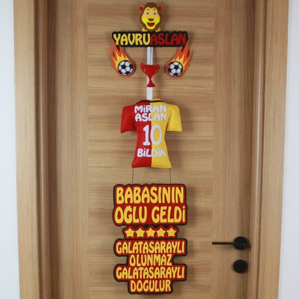 Yakın çekim: Yavruaslan figürü, kupa ve yanan futbol topu detayları