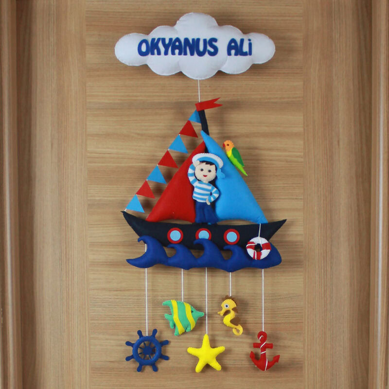 Yakın çekim: Denizci figürü, yelkenli gemi ve dalgalar keçe detayları