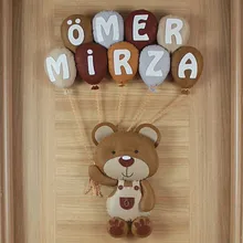 Yakın çekim: Ömer Mirza yazılı nötr renkli keçe balon detayları