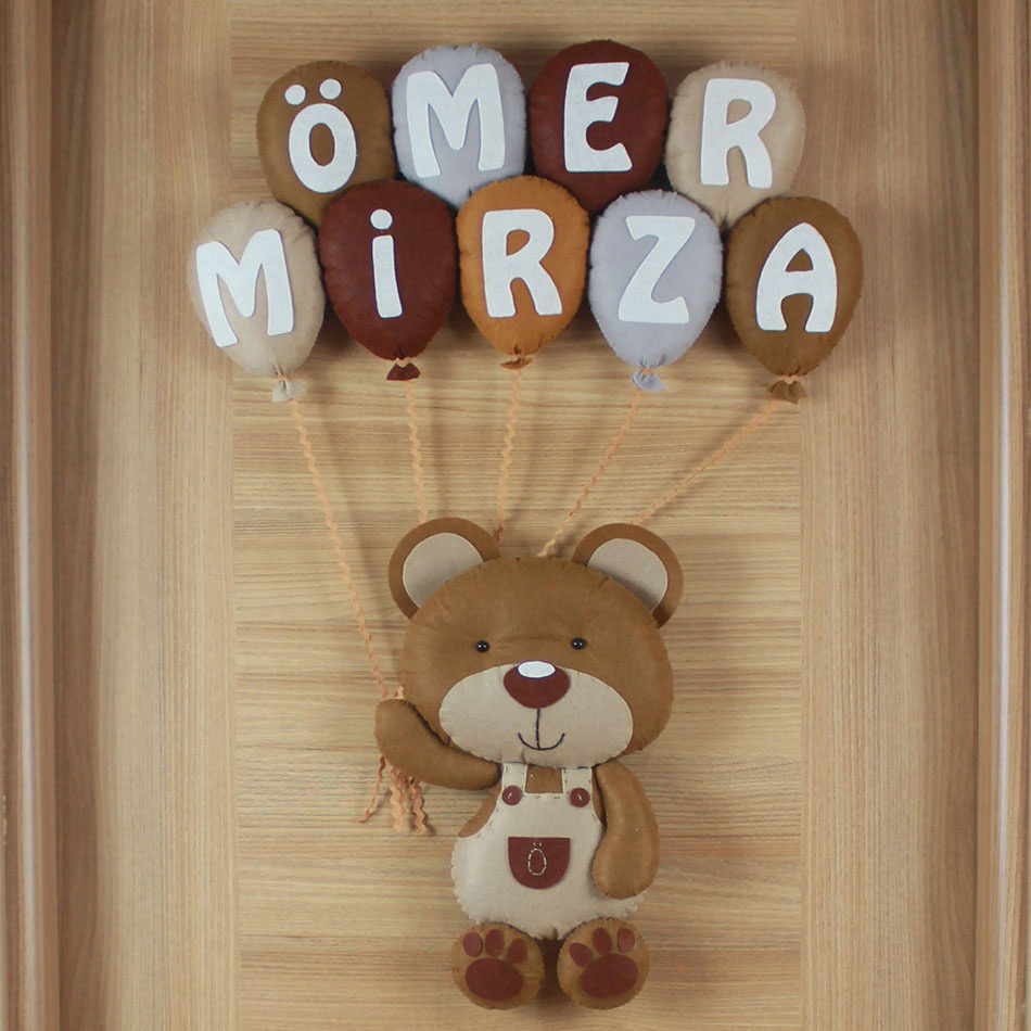 Yakın çekim: Ömer Mirza yazılı nötr renkli keçe balon detayları