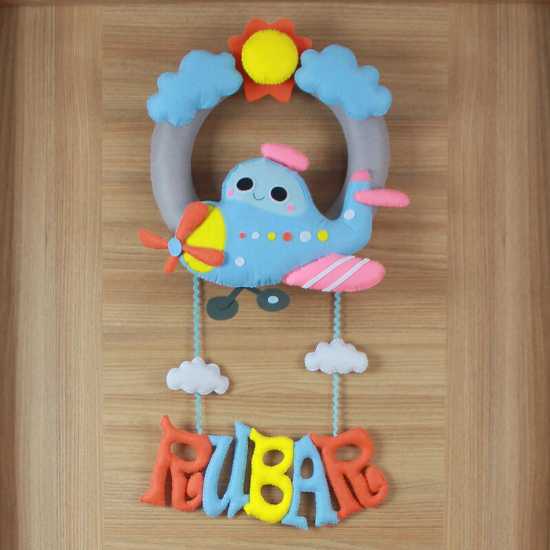 Yakın çekim: Uçak figürü, güneş, bulut ve simit keçe detayları