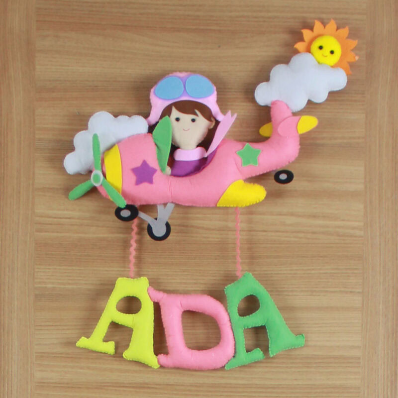 Yakın çekim: Pilot kız figürü ve pembe keçe uçak detayları