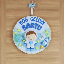 Yakın çekim: Keçe astronot figürü ve Bartu ismi detayı
