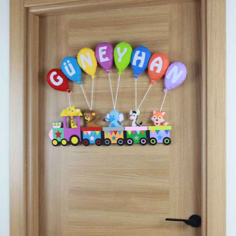 Keçe tren vagonları içinde zürafa, aslan ve fil figürleri