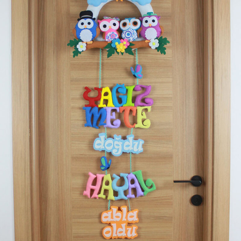 Yakın çekim keçe baykuş ailesi: anne, baba ve iki kardeş baykuş figürü