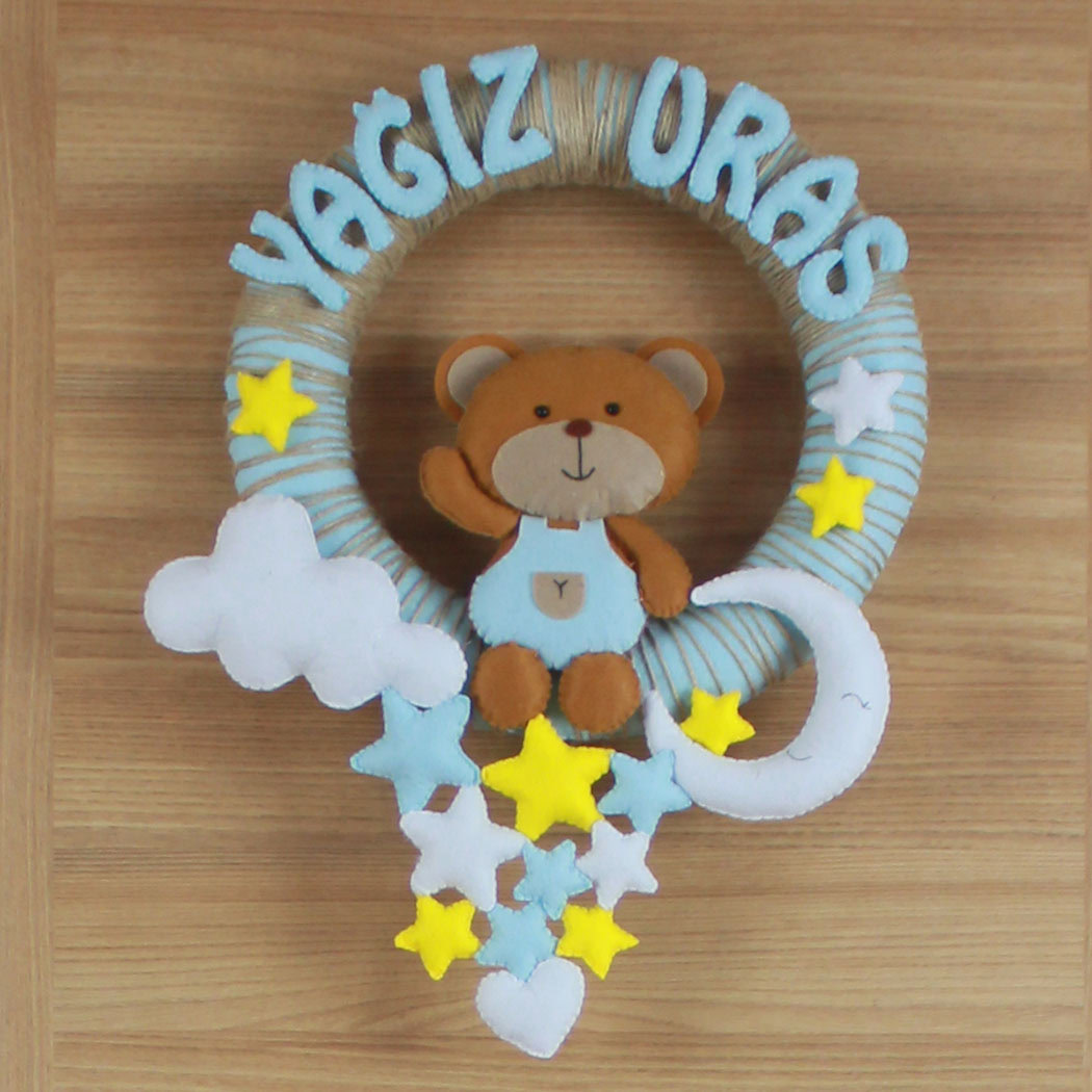 Yakın çekim keçe ayıcık figürü ve Yağız Uras yazılı harfler
