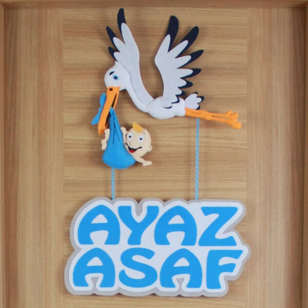 Keçe leylek figürü ve mavi bebek çıkını detay çekimi