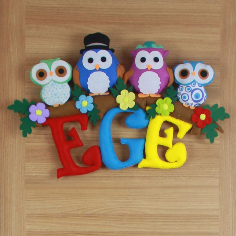 Keçe baykuş figürleri detay çekimi; şapkalı ve çiçekli baykuşlar