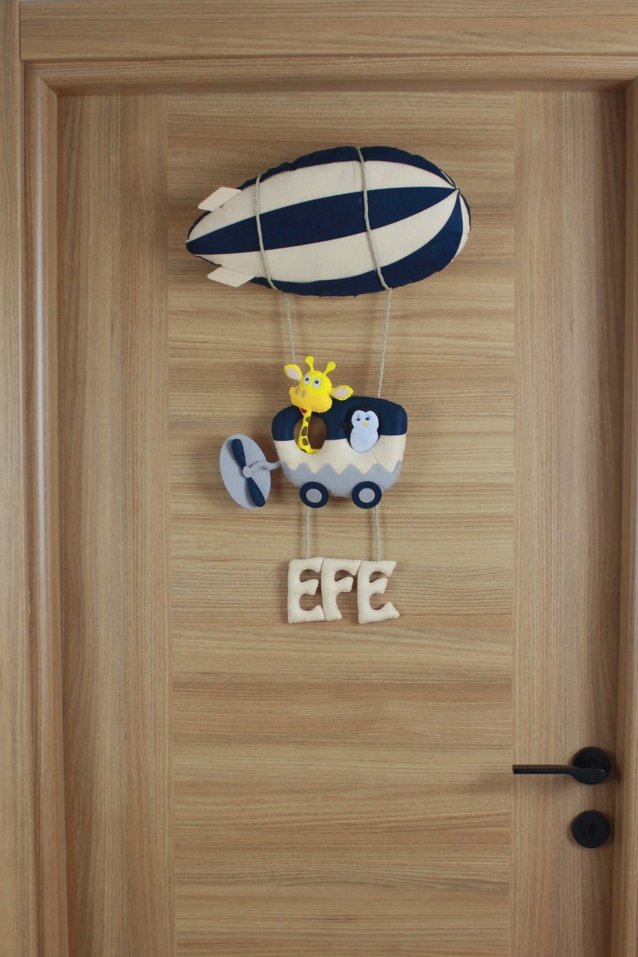 Efe İsimli Lacivert Zeplinli Safari Keçe Bebek Kapı Süsü – kapıda görünümü